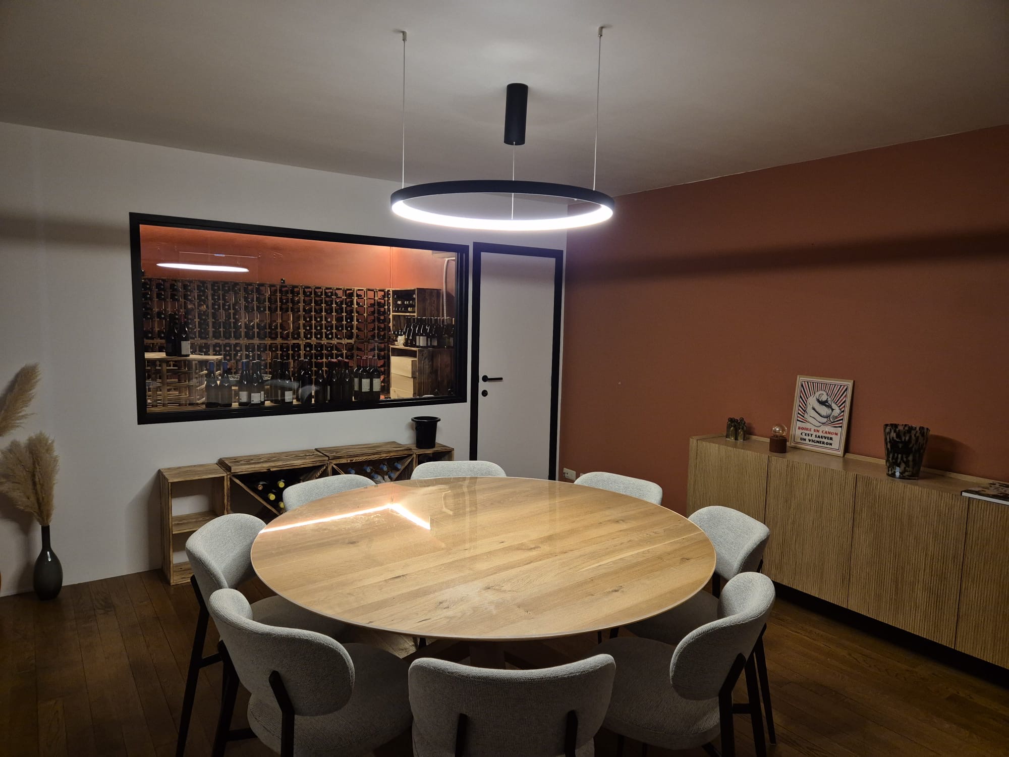 Luminaire suspendu design installé dans une salle à manger avec cave à vin